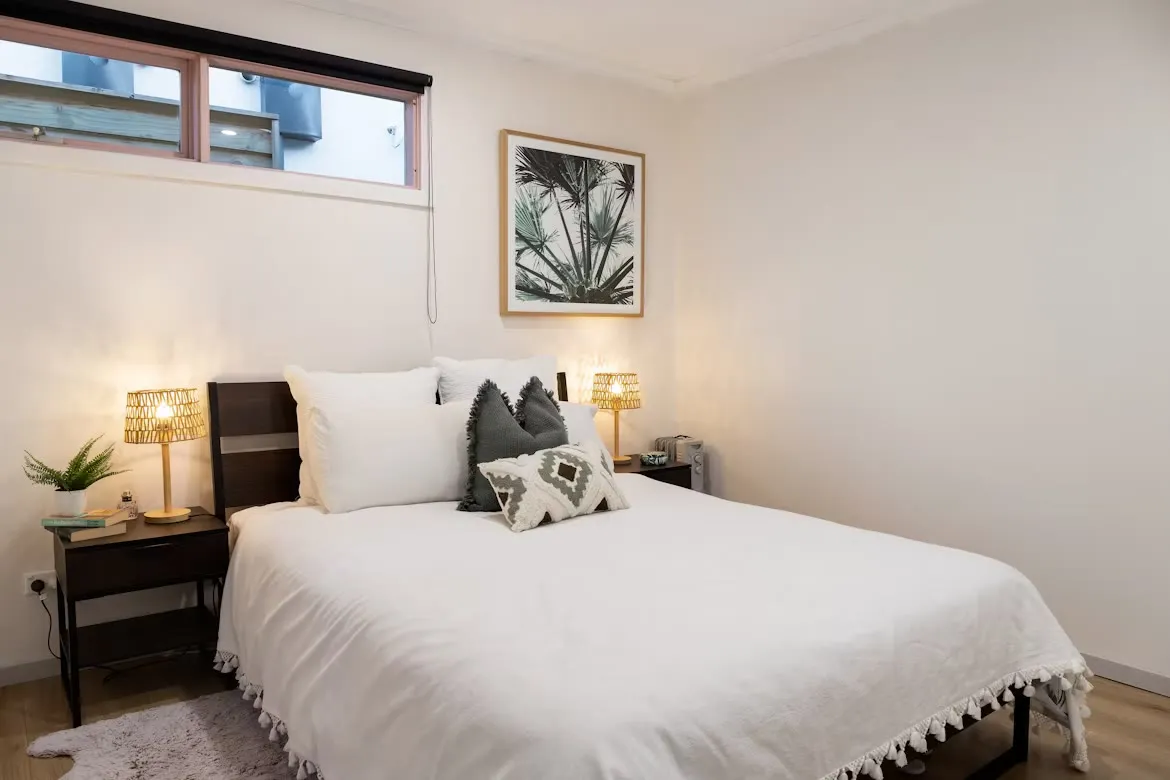 A calm, made bedroom with a window